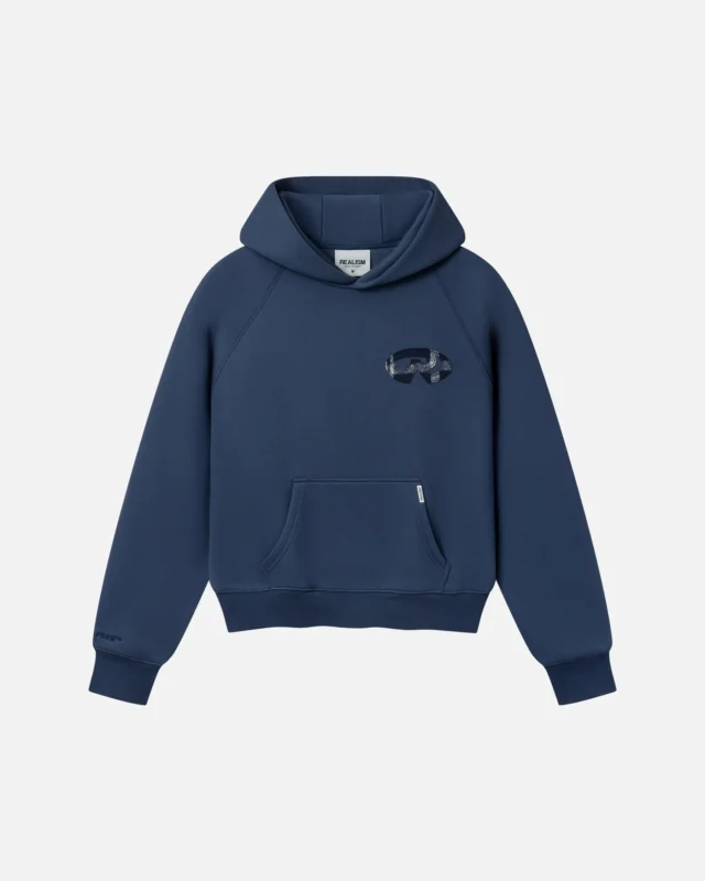 Front view of the Realism Legacy Hoodie V2 in navy blue featuring a plaid graphic chest emblem and kangaroo pocket on a white background.